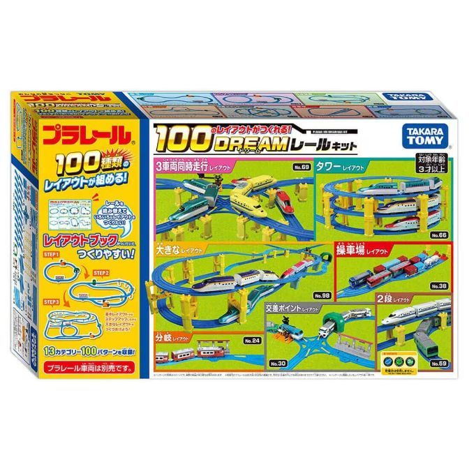 The image shows a Takara Tomy Plarail 100 Dream Rail Kit box. The box is colorful and features various train track layouts, including a tower layout, a large layout, a depot layout, a two-level layout, and an intersection layout. The box also indicates that the kit allows for 100 different layouts and is suitable for children aged 3 and up.