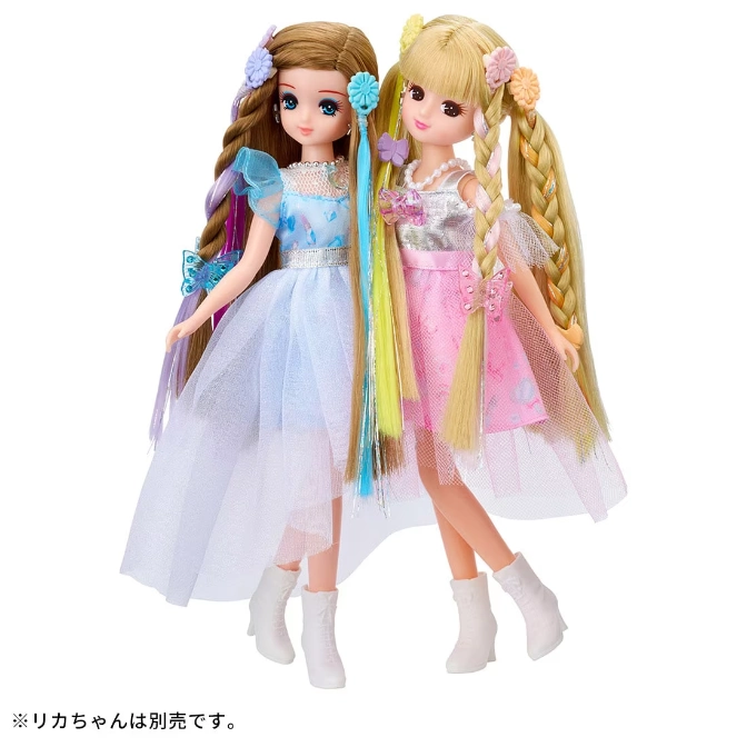  Two Licca dolls in dresses with long hair and white boots. One has brown hair and a blue dress, the other blonde and pink.