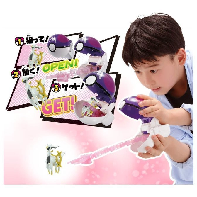  Boy playing with a purple Poké Ball toy that launches a white and gold Pokémon figure with a pink projectile.