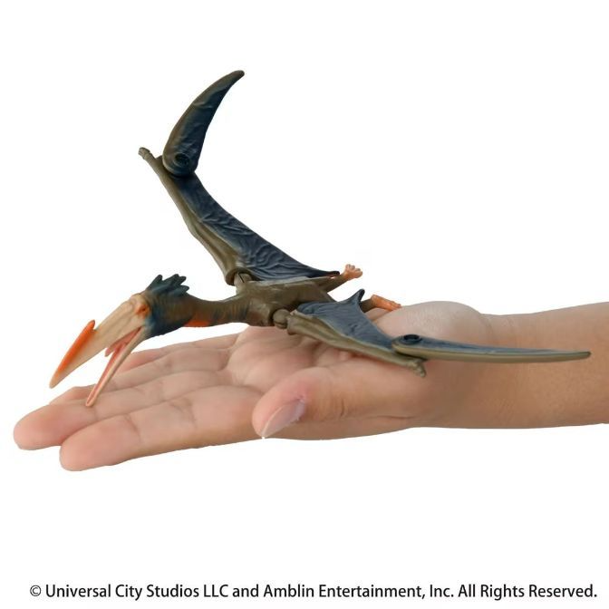  Pterodactyl toy with articulated wings and jaw, resting on a hand.