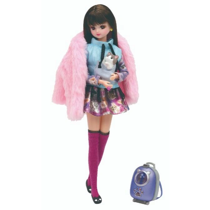 Licca doll with pink coat, skirt, socks, and cat backpack. Holding a small cat toy.