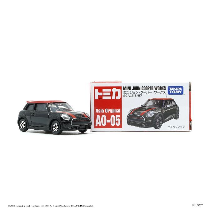  Black Mini Cooper toy car with red roof and stripes, next to its packaging.