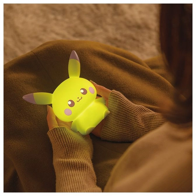  Illuminated Pikachu night light toy held by a person.