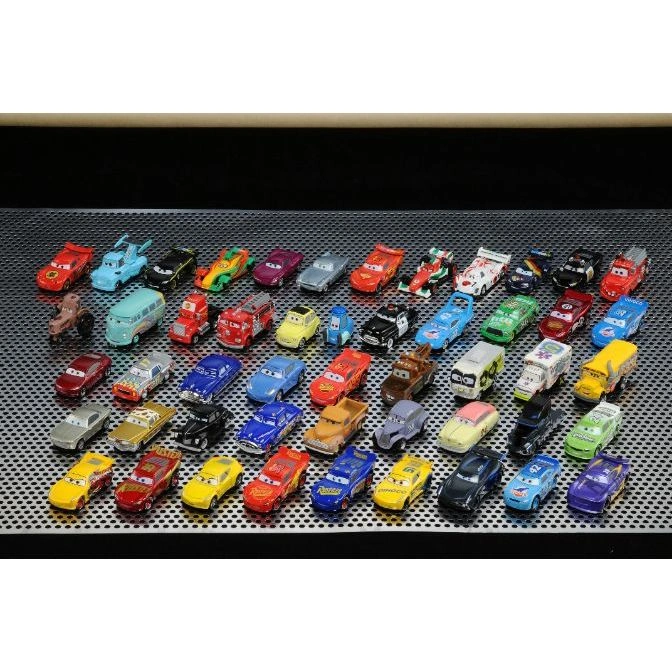  Collection of toy cars, various colors and designs, displayed on a metal surface.