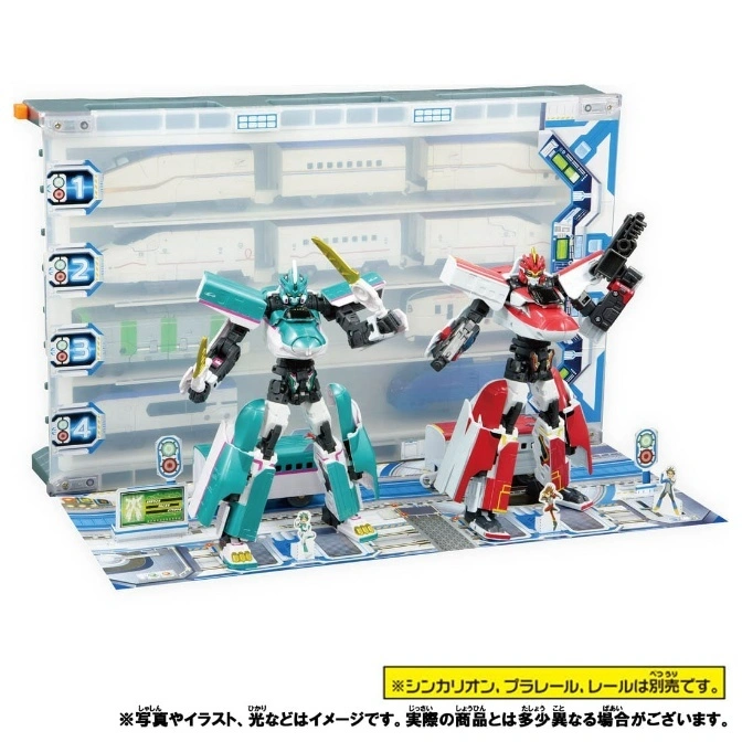  Shinkalion robots with display case. Green robot holds sword, red robot holds gun. Figures stand on platform.