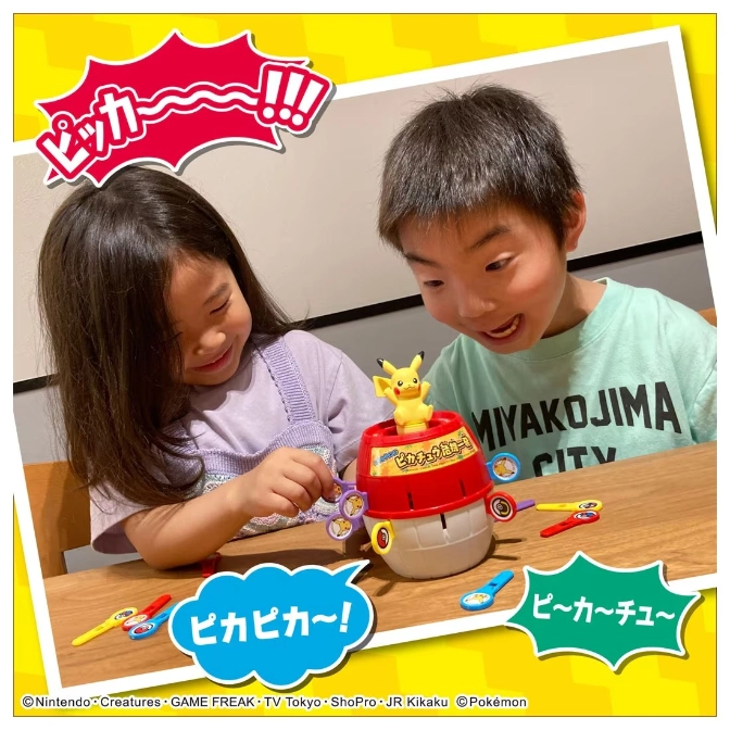  Kids play with a Pikachu game. It has a barrel base, Pikachu on top, and tools to catch Pikachu.