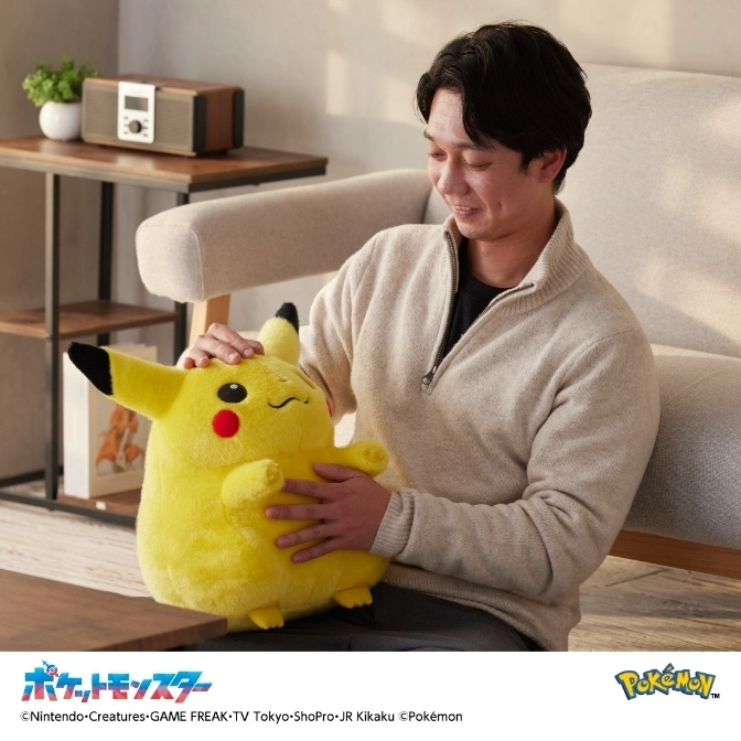  Man holding a large Pikachu plush toy with closed eyes and red cheeks.
