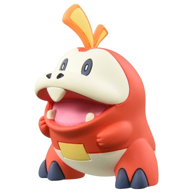 Fuecoco Pokémon toy figure with orange body, cream face, and yellow accents.