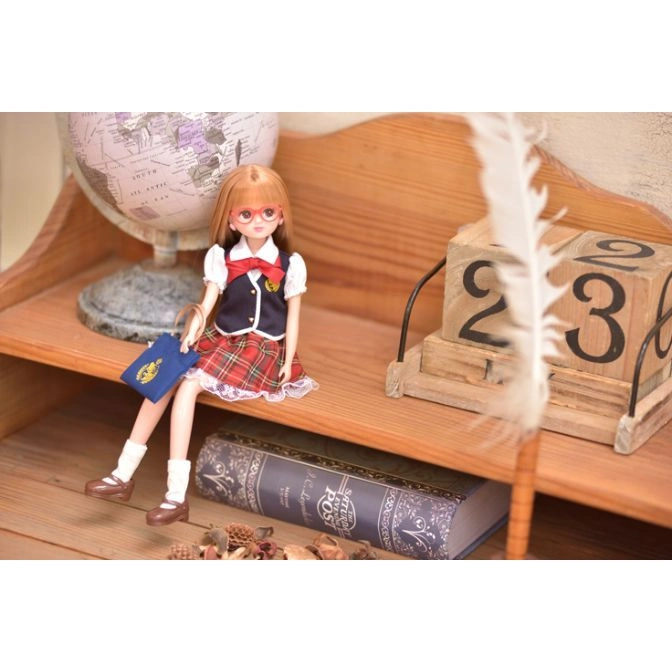  Doll in school uniform with a book and globe on a wooden shelf with a calendar.