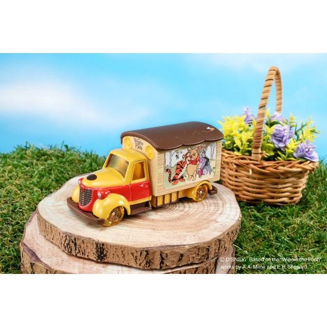  Winnie the Pooh toy truck on wood slice, with basket of flowers. Yellow and red cab, Pooh characters on the side.