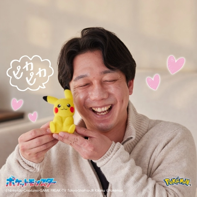  Smiling man holding a Pikachu plush toy. Hearts and a speech bubble surround them.