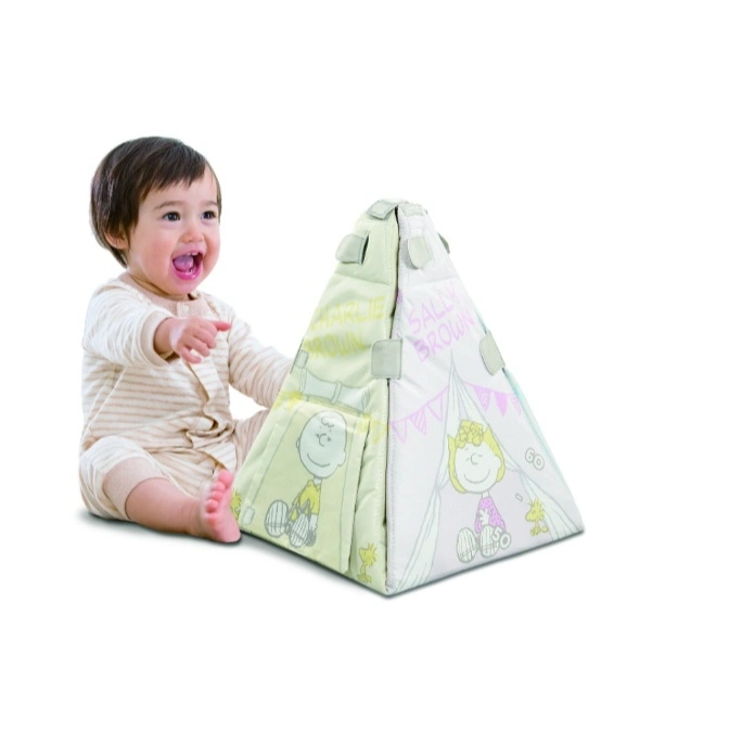  Baby pointing at a triangular Peanuts-themed soft play toy featuring Charlie Brown and Sally Brown.