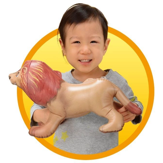  Child holding inflatable lion toy with red mane and tan body against a yellow background.