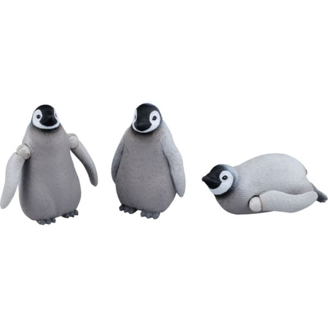 Three emperor penguin chick toys: one standing with articulated arms, one standing, and one lying down.