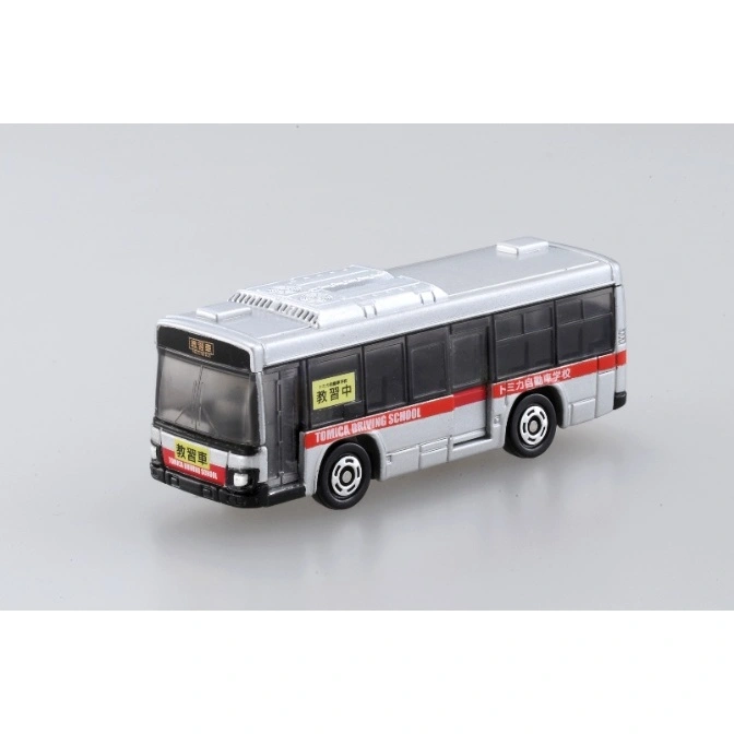  Silver Tomica driving school bus toy with red stripe and Japanese text.