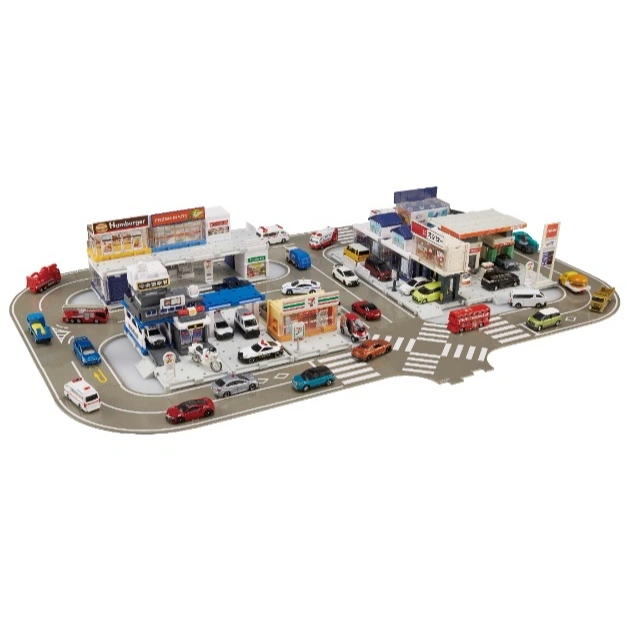 Toy city playset with miniature buildings, cars, and trucks on a road mat.