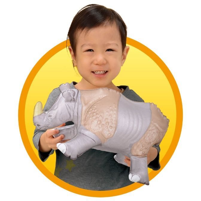  Child holding a plush rhino toy with a yellow horn and textured skin.