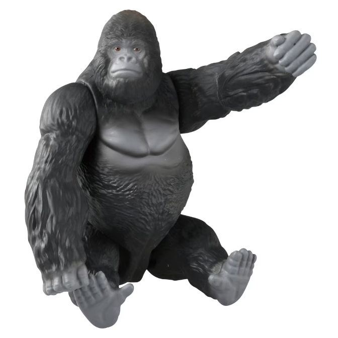  Gray gorilla toy with arm raised, sitting down.