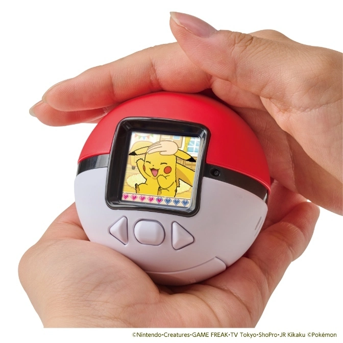 Pokémon Poké Ball toy with Pikachu on screen, held in hands. Red and white design with button controls.
