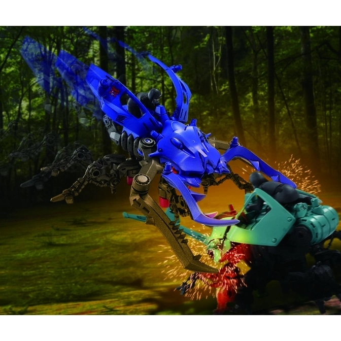  Blue beetle robot toy with rider attacking another robot in a forest setting, sparks flying.