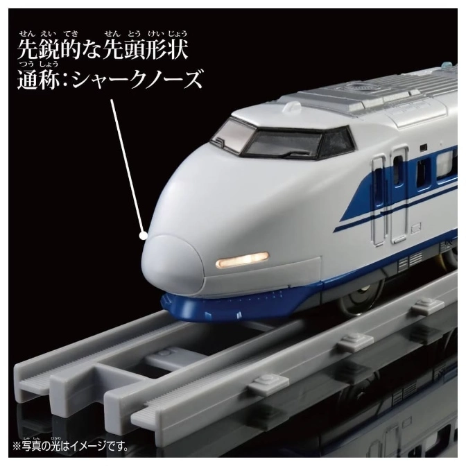  Toy bullet train with a shark-nose design on a gray track. The train is white with blue stripes.