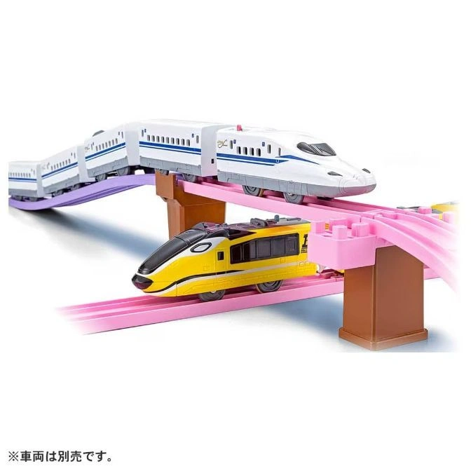  Toy bullet trains on a pink track with brown supports. One train is white and blue, the other is yellow and black.