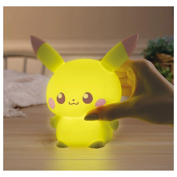  Illuminated Pikachu night light with pink cheeks and ear tips, being touched by a hand.