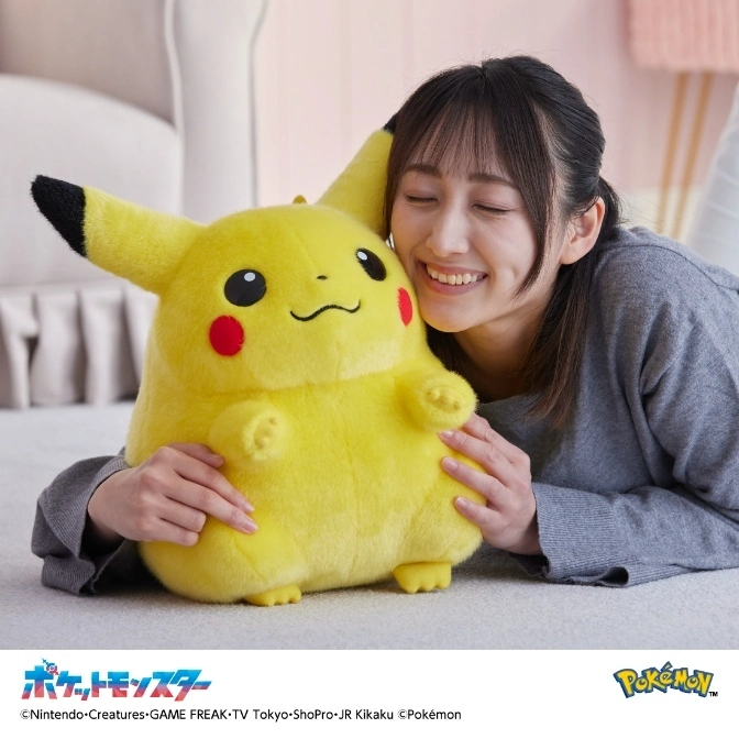  Woman hugging a large, plush Pikachu toy with red cheeks and black-tipped ears.