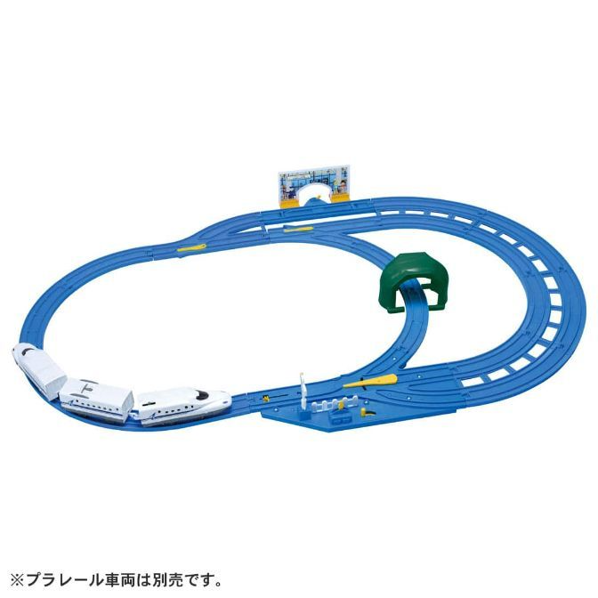  A toy train set with a blue track, a white train, a green tunnel, and a blue station.
