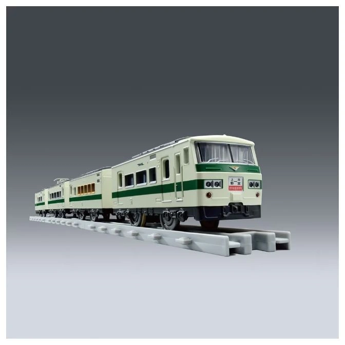  Toy train with green and cream livery on a grey track.
