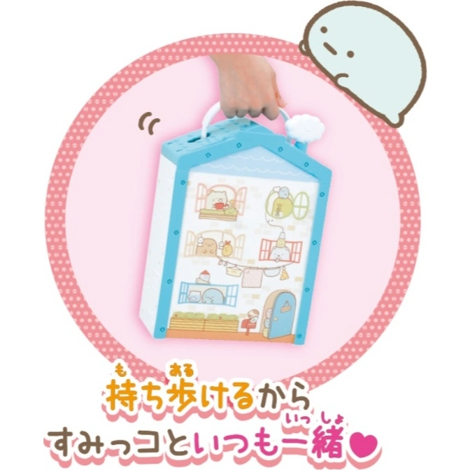  Sumikko Gurashi house playset with handle, held by a hand, inside a pink polka dot circle.
