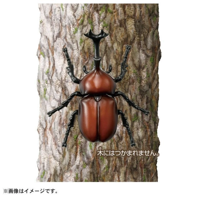  Toy rhinoceros beetle on tree bark. Brown body, black legs and horn.