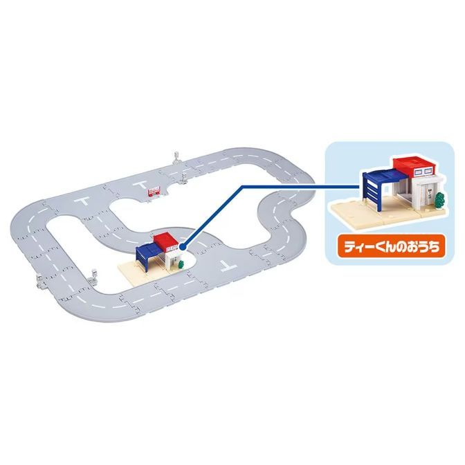 Toy road track with miniature buildings, including a house and a service station.