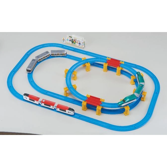  Toy train set with blue tracks, red bridges, and three model trains in red, green, and grey.