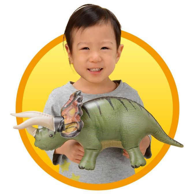  Child holding a green inflatable Triceratops toy with horns and frill.