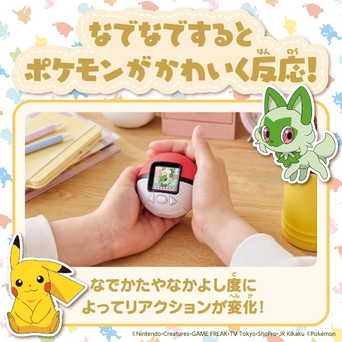  Pokémon Poké Ball toy with screen showing Sprigatito. Hands are petting the toy. Pikachu and Sprigatito stickers.