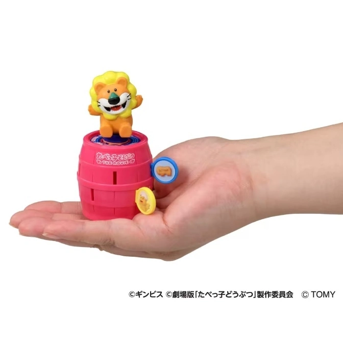  Lion figure on a pink barrel toy with animal tokens, held in a hand.
