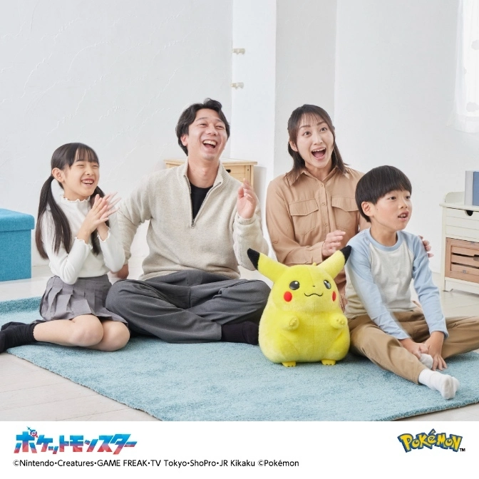  Family watching TV with Pikachu plush. Everyone is smiling and excited.