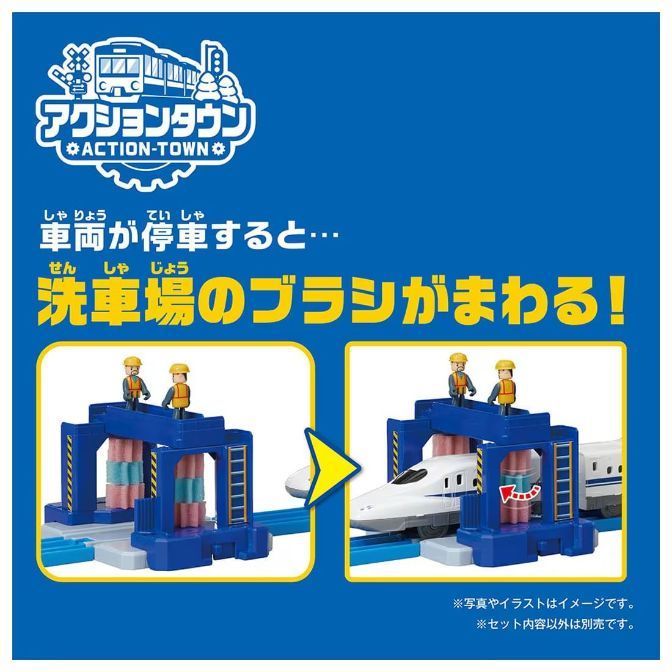  This is a product image of an Action-Town train set. The set includes a train car wash with rotating brushes. The image shows the train car wash with two figures standing on top of it. The train is shown going through the car wash and the brushes are rotating.