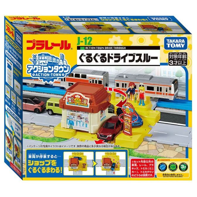  The product image shows a Takara Tomy Plarail J-12 Action Town Drive Through playset. The playset features a train track, a burger shop, cars, and figures. The packaging is yellow and blue, and it includes Japanese text.