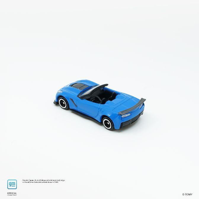  Blue toy Corvette convertible with black interior and spoiler on a white background.
