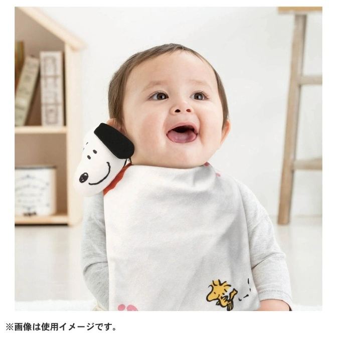  Baby wearing Snoopy bib with Snoopy plushie attached to the shoulder.