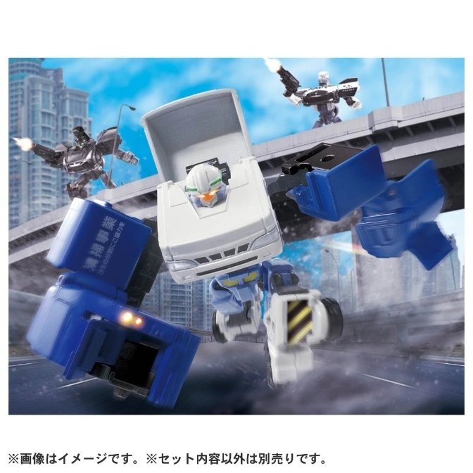  Toy robots mid-battle. A white truck-bot is center, with blue and black bots firing weapons in the background.
