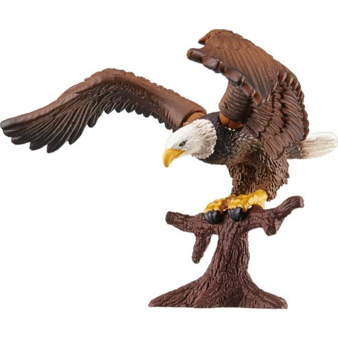 Toy eagle with brown wings and white head perched on a brown tree branch.