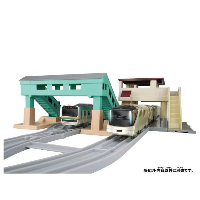  A toy train set with two trains, a bridge, and a station.