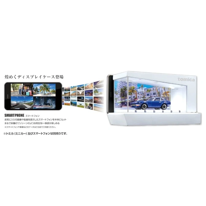  Tomica display case with blue toy car, smartphone showing images as backdrop.