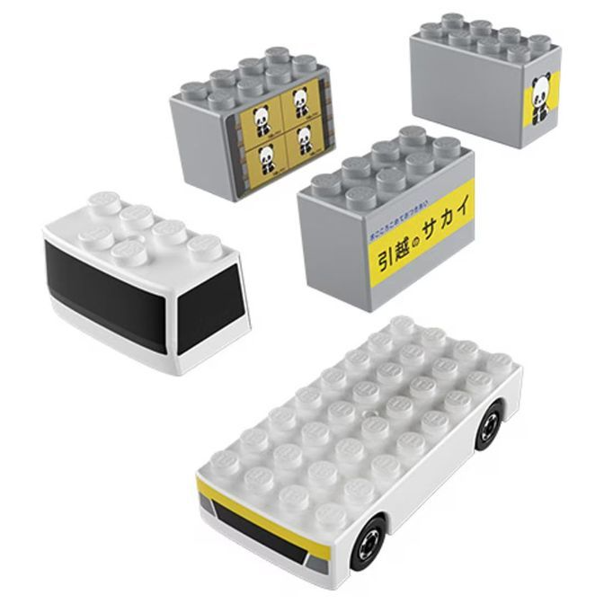  Toy building blocks resembling moving company trucks and a car, made of interlocking plastic bricks.