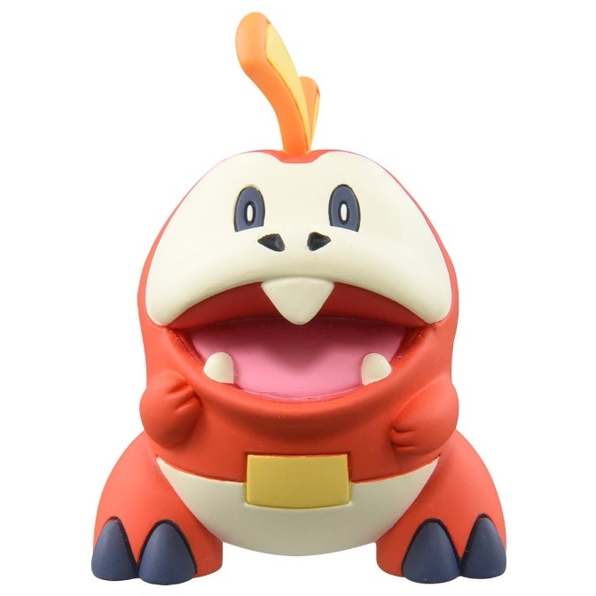 Fuecoco Pokémon toy with open mouth, orange body, and cream-colored head.