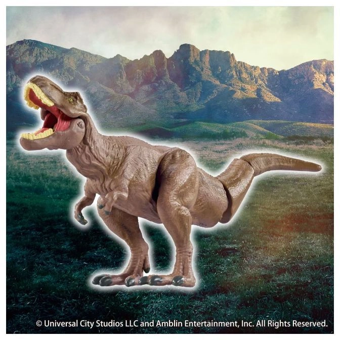  Brown Tyrannosaurus Rex toy with open mouth standing on a green field with mountains in the background.