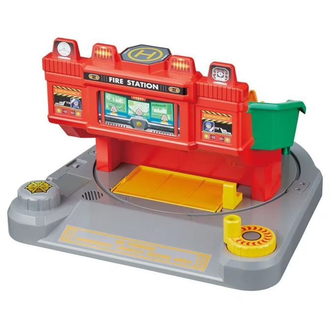  Toy fire station with lights, helipad, and emergency screens on a gray base.